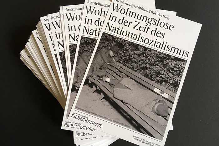 Flyer zur Ausstellungseröffnung mit Vortrag - "Wohnungslose in der Zeit des Nationalsozialismus". Auf dem historischen Foto schlafen zwei Menschen auf einer Parkbank.